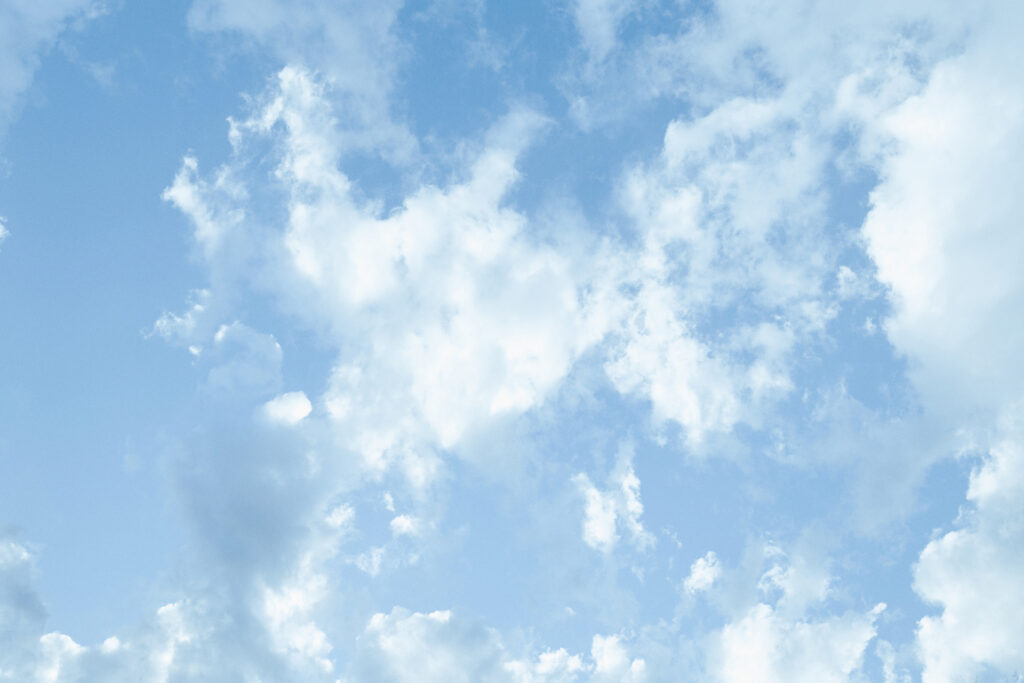 Blue sky with scattered fluffy clouds.