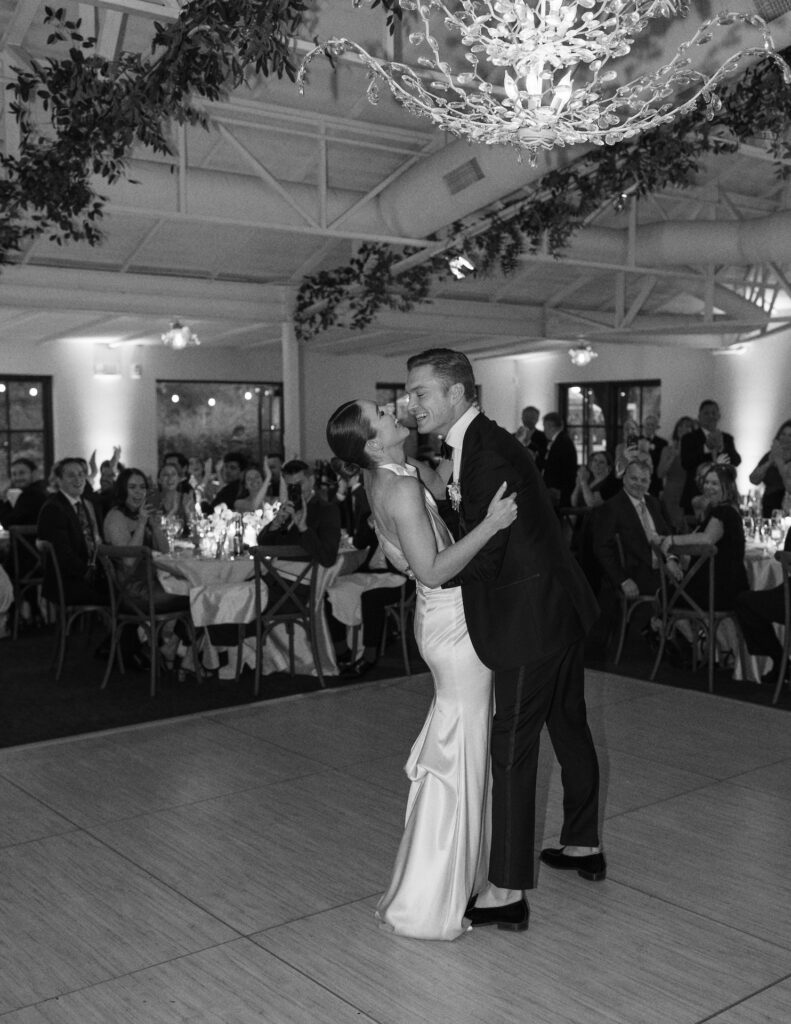 Bride and groom dancing on indoor reception dance floor.