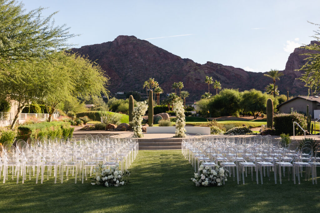 Outdoor wedding ceremony set at Mountain Shadows resort with ground floral at back of aisle and floral pillars in altar space.