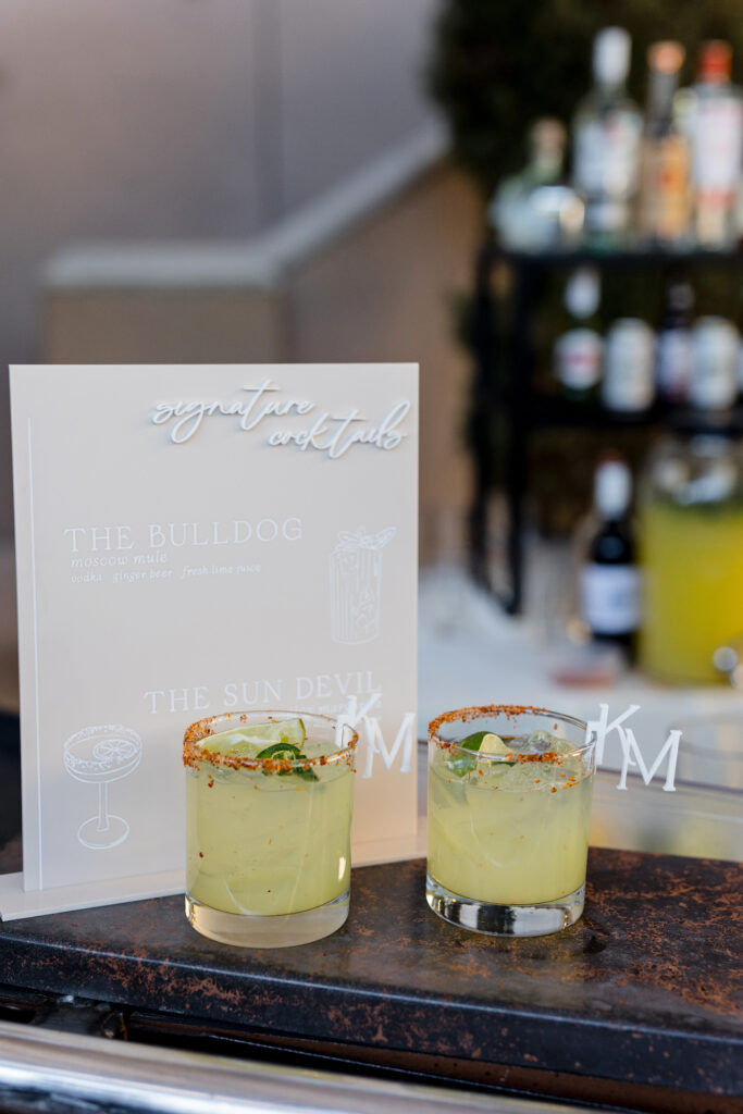 Custom cocktail wedding sign with two cocktails placed in front of it.