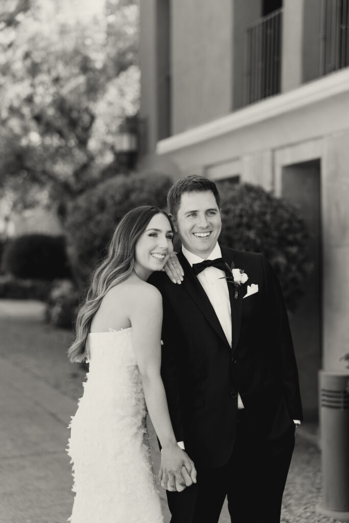 Bride and groom standing close, both smiling.