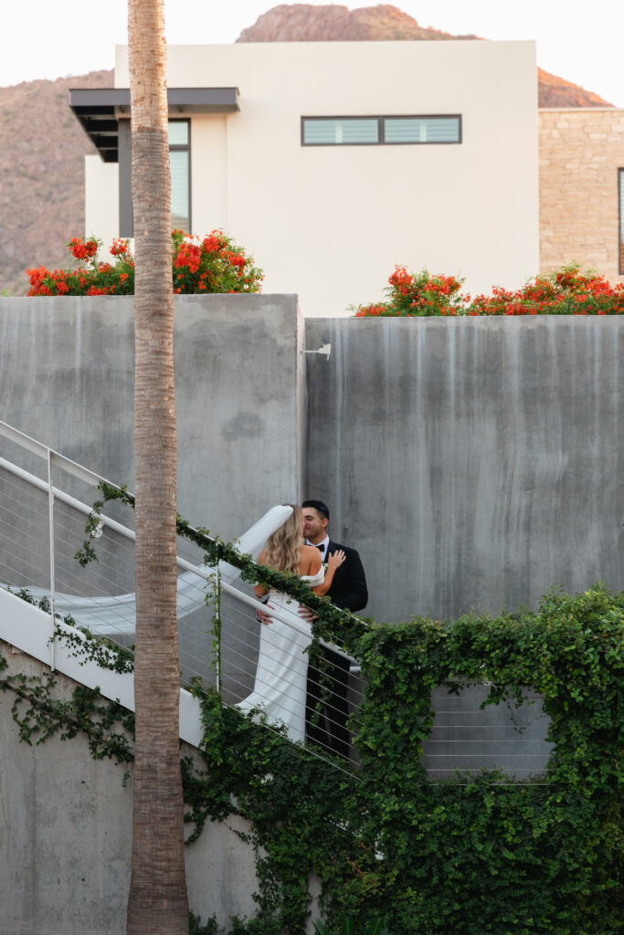 Bride and groom embracing on Mountain Shadows resort stairs.