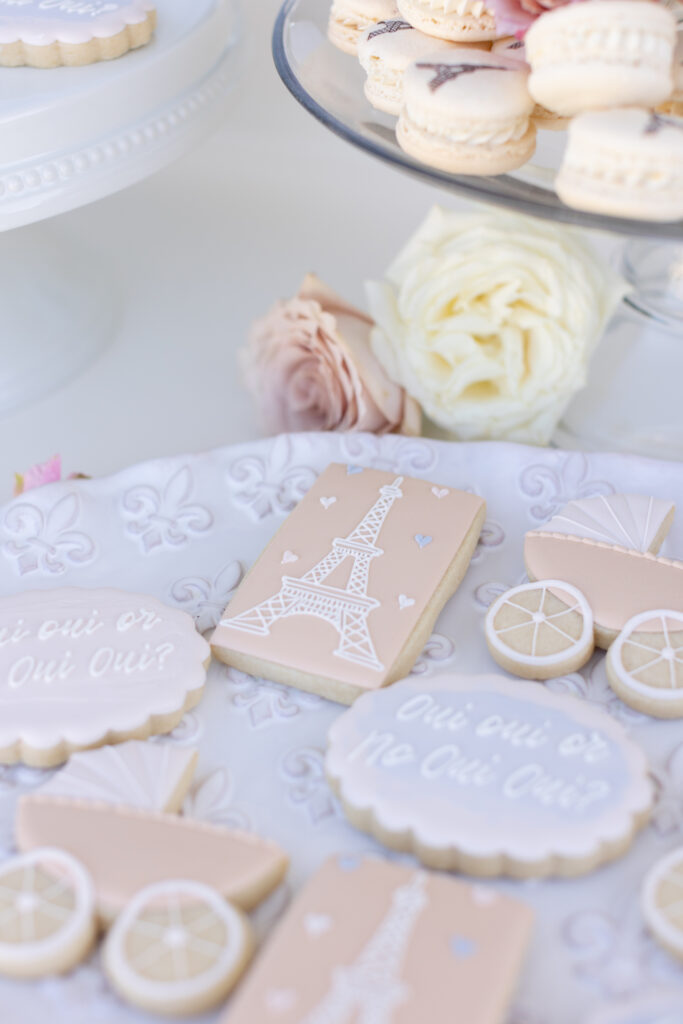 Pink Paris themed baby shower cookies and macaroons.