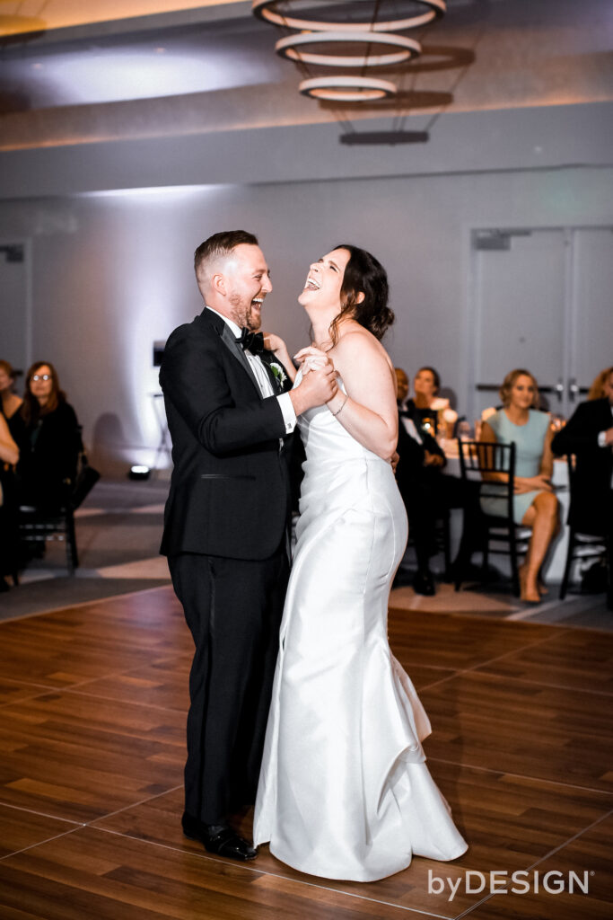 Bride and groom dancing at indoor wedding reception.