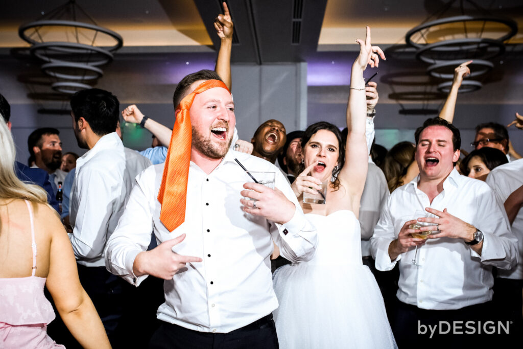 Bride and groom dancing with wedding guests at reception.