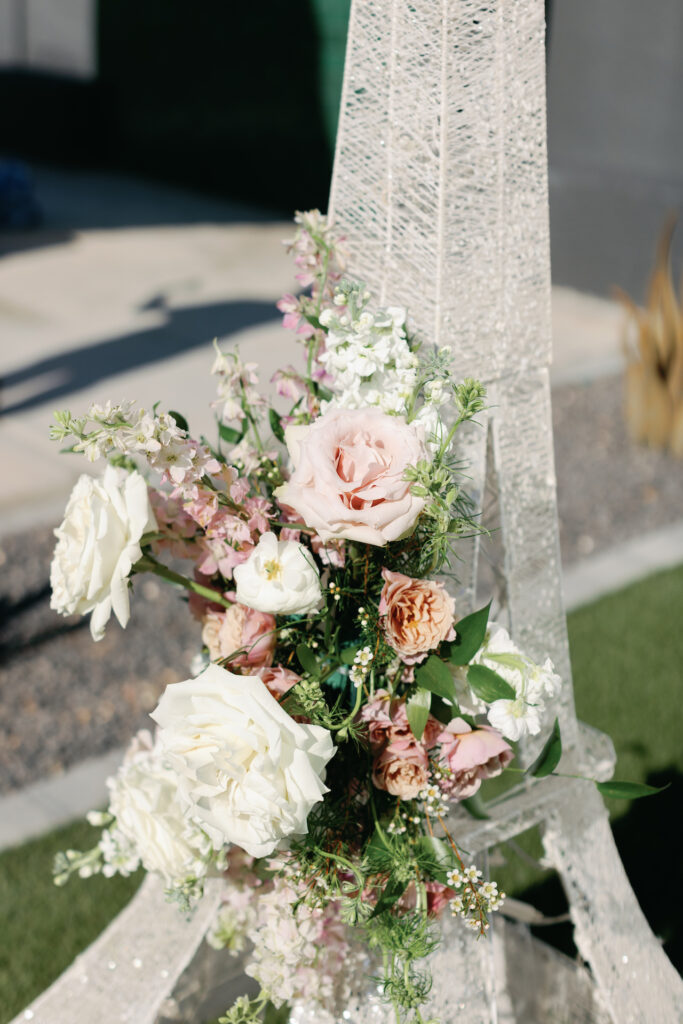 Pink and white flowers wadded to a miniature Eiffel Tower.