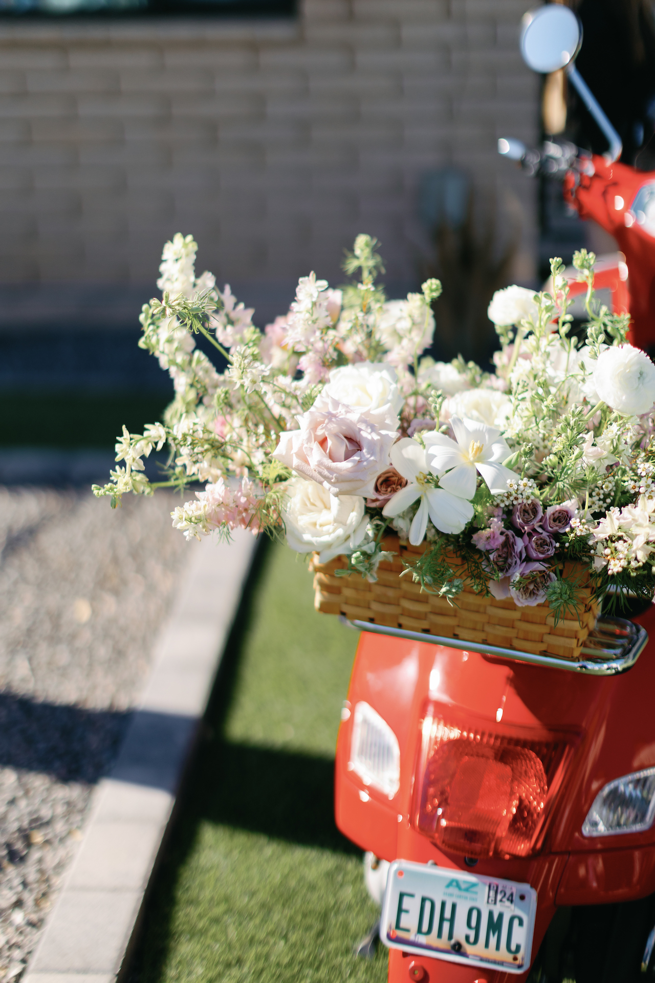 Flowers placed on the back of a red scooter.