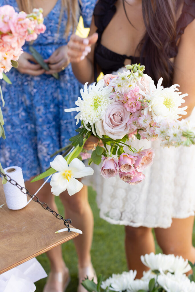 White and pink flowers held by woman.