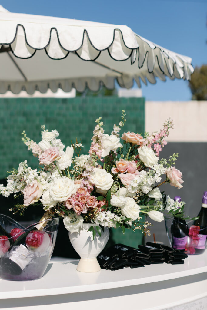 Bar top floral arrangement of white and pink flowers.