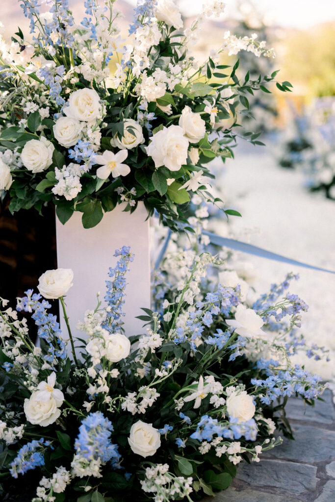 Floral details of wedding ceremony back of aisle floral in blue and white colors.