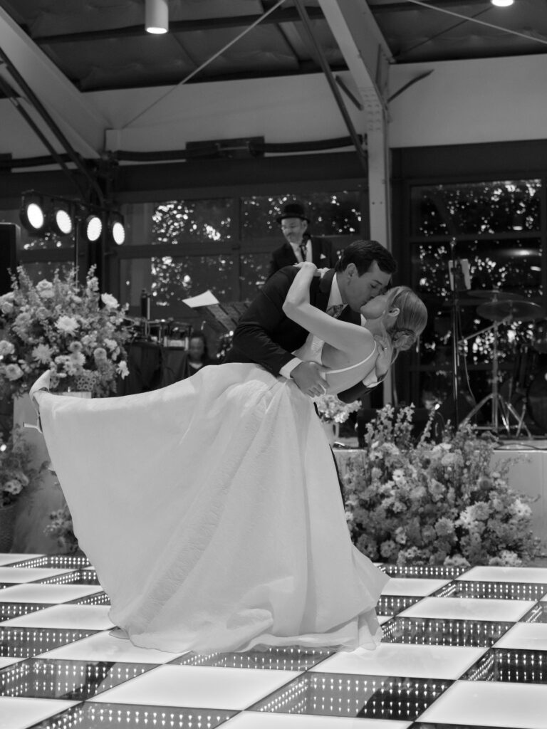 Groom kissing and dipping bride during wedding reception dance.