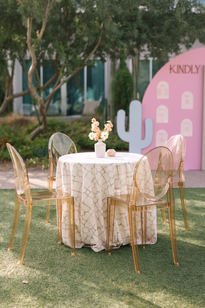 Cocktail hour table with small centerpiece of flowers and a votive candle in center.