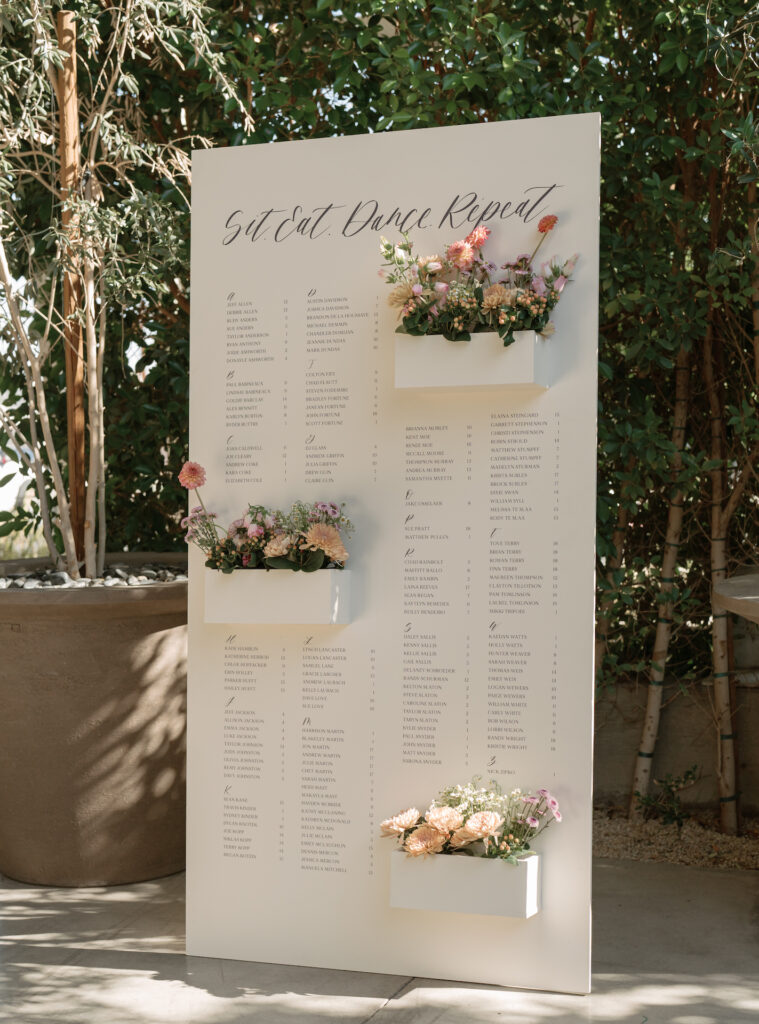 Custom wedding reception escort sign with boxes for flowers in three places.