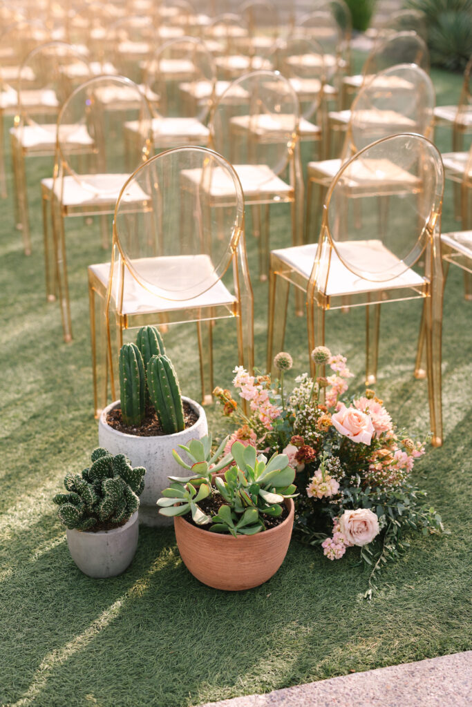 Wedding ceremony back of aisle ground arrangements of cacti and succulents and ground floral arrangement.