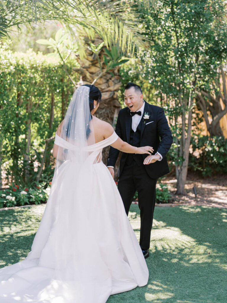 Groom seeing bride for wedding first-look in outdoor desert space.
