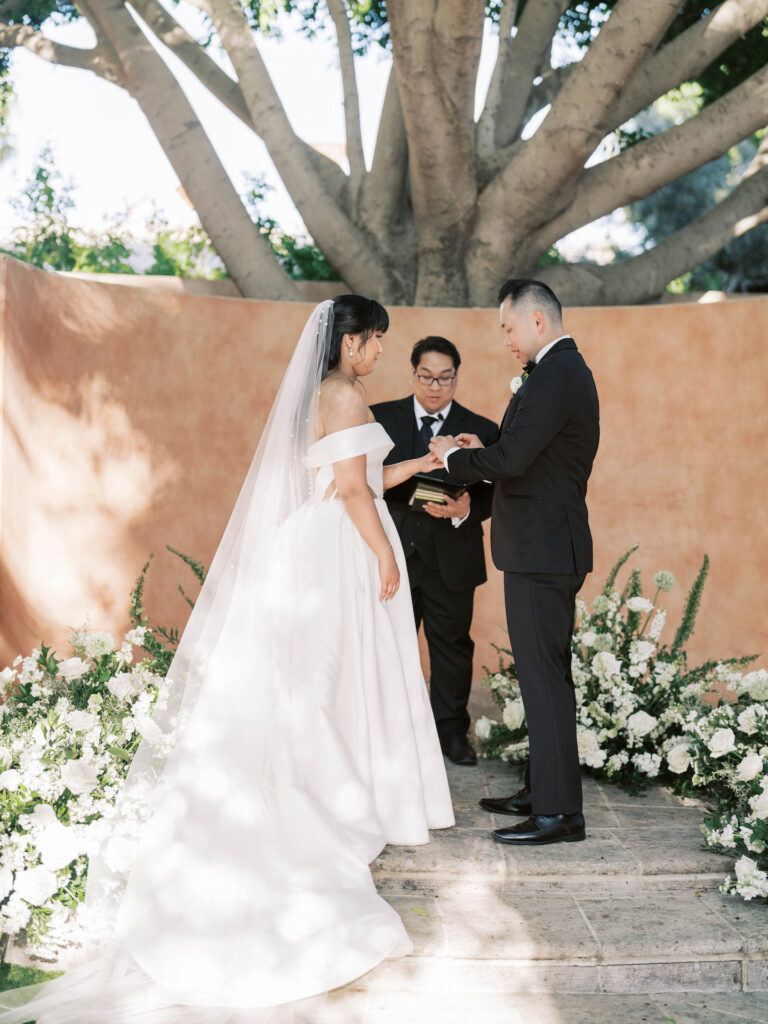 Bride and groom in wedding ceremony altar space with officiant during cermemony.