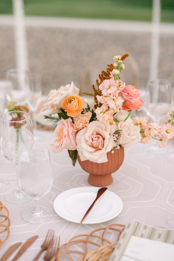 Wedding reception flower centerpiece in terra cotta pot.