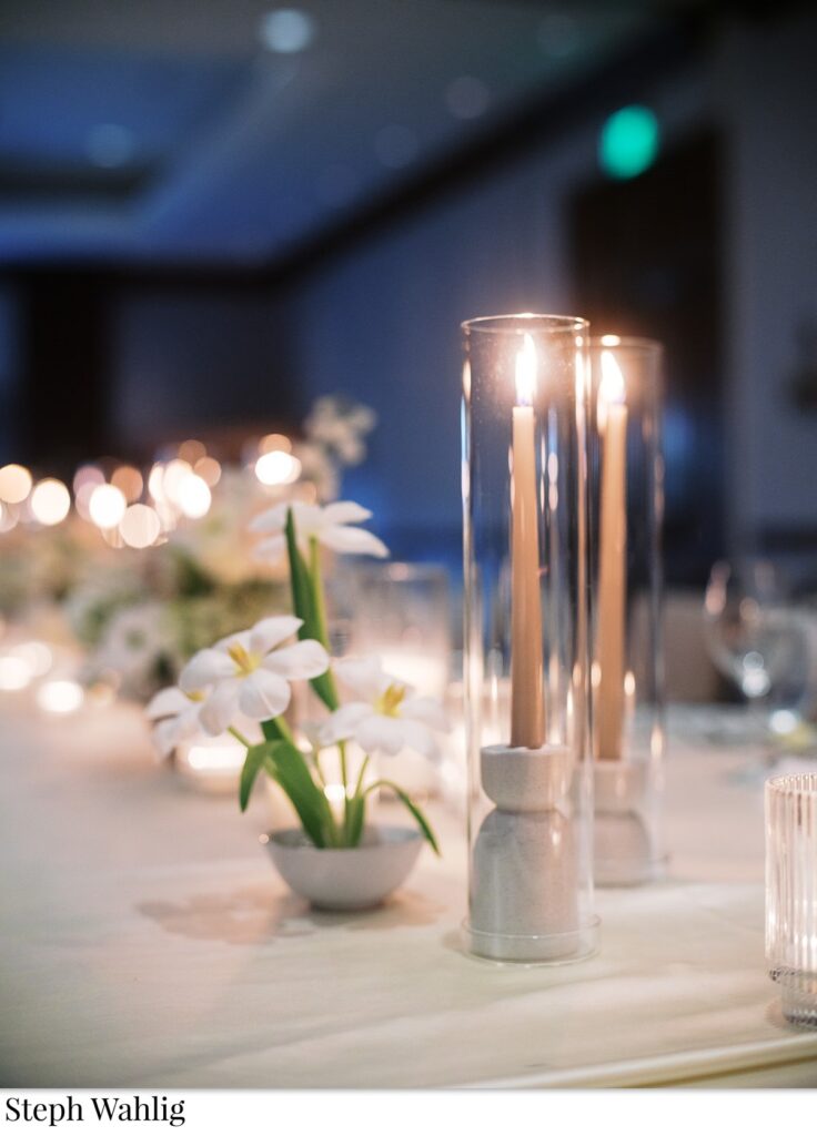 Small modern floral arrangement and taper candles.
