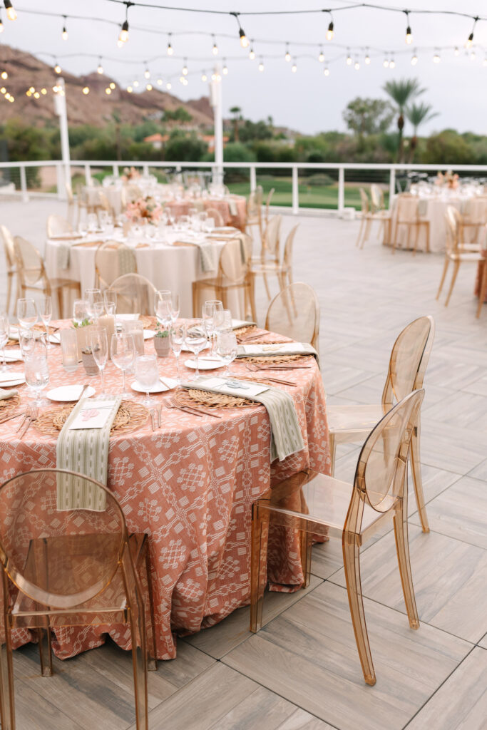 Wedding reception round tables on Mountain Shadows patio with candle and floral centerpieces.