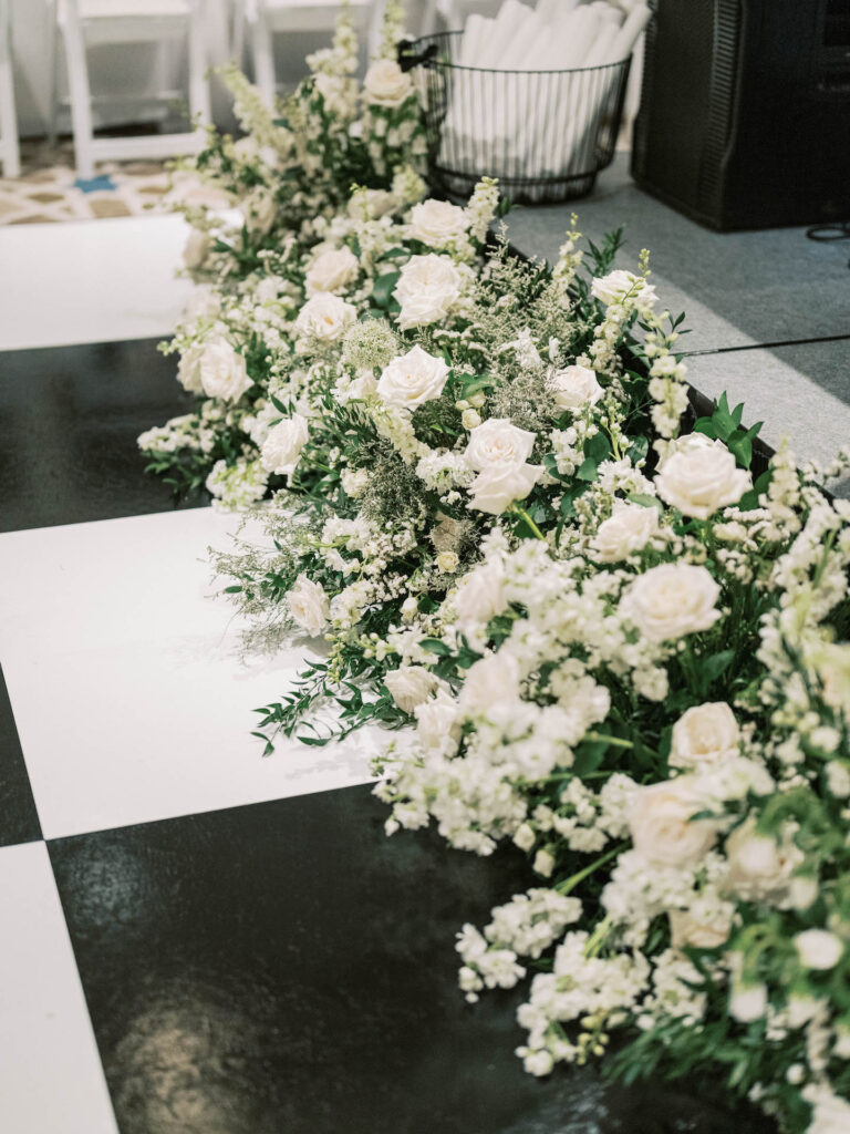 White flowers and greenery wedding reception dance floor decor.