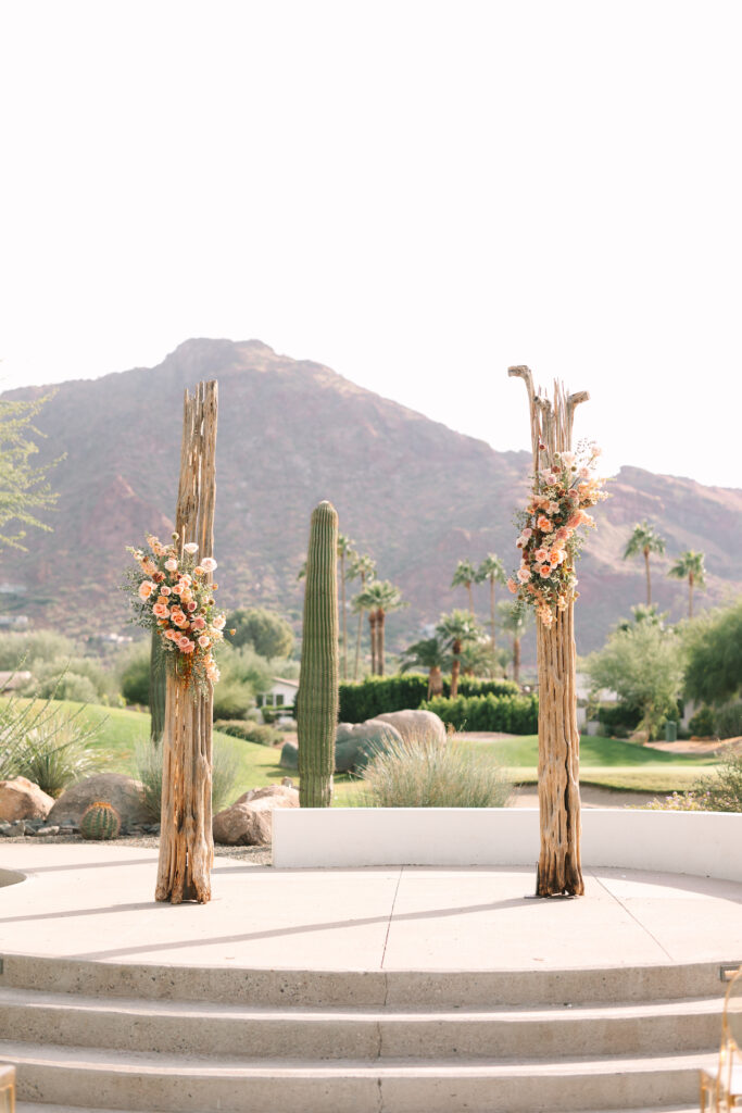 Saguaro cactus ribs with flower arrangements attached to them for wedding ceremony altar design.