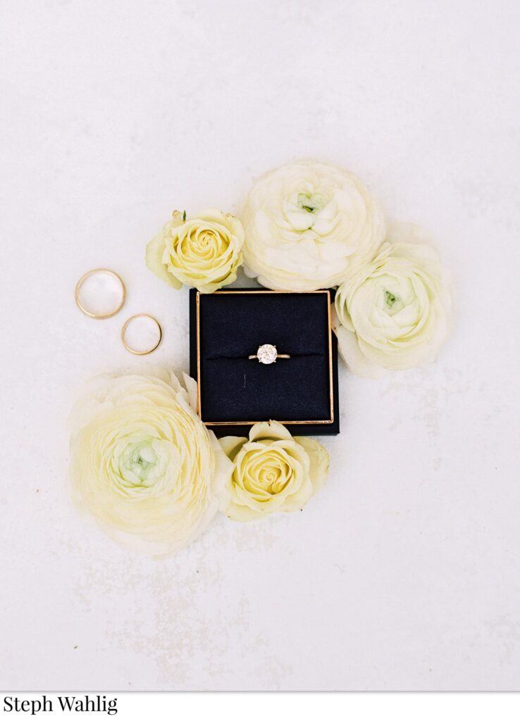 Wedding ring flat lay with white flowers.