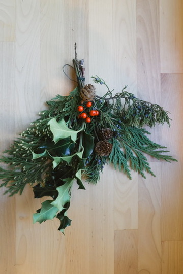 Greenery including evergreens, pinecones, and holly arrangement.