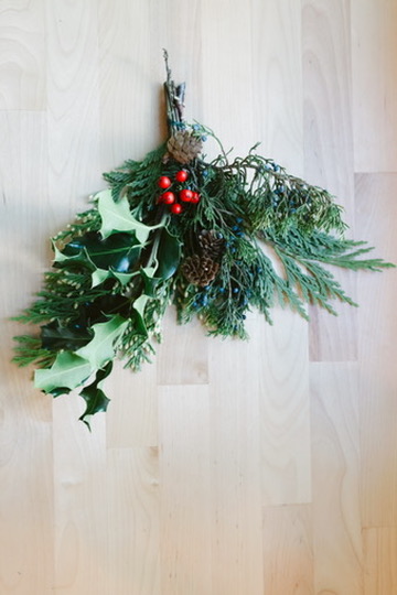 Greenery including evergreens, pinecones, and holly arrangement.