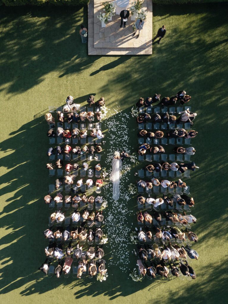 Overhear ceremony view of bride walking down aisle at outdoor El Chorro wedding.