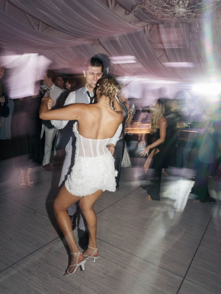 Bride and groom dancing at indoor wedding after party.