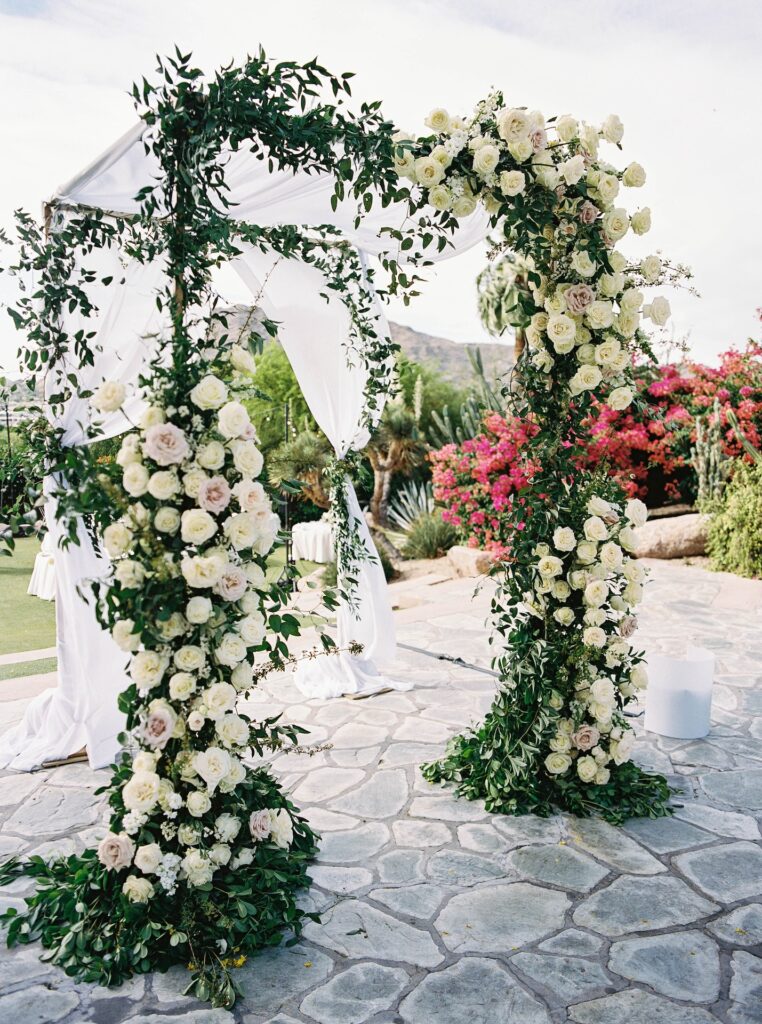 Custom chuppah flower installation with lush white and blush flowers and greenery.