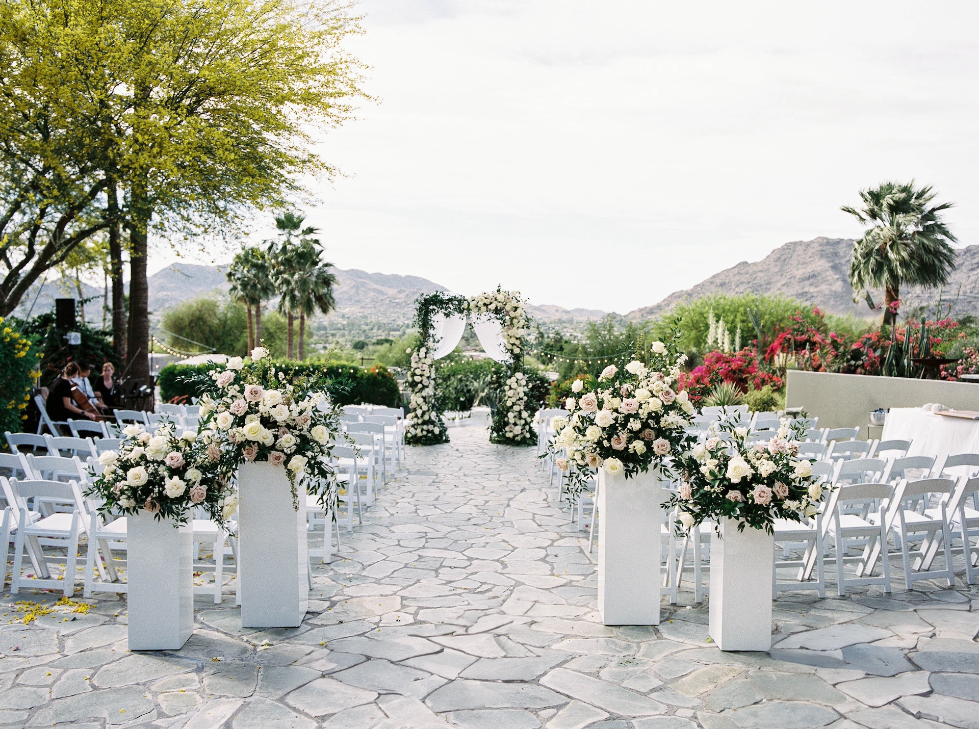 Outdoor wedding ceremony at Sanctuary Resort with chuppah flowers and back of aisle flowers.