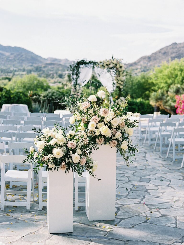 Outdoor wedding ceremony at Sanctuary Resort with chuppah flowers and back of aisle flowers.