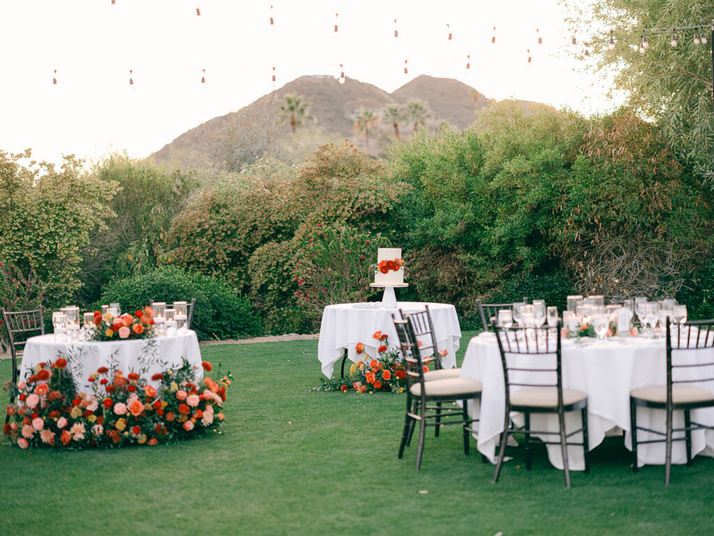 Outdoor wedding reception at Paradise Valley Country Club with round guest table, sweetheart table, and cake table. All with floral designs.